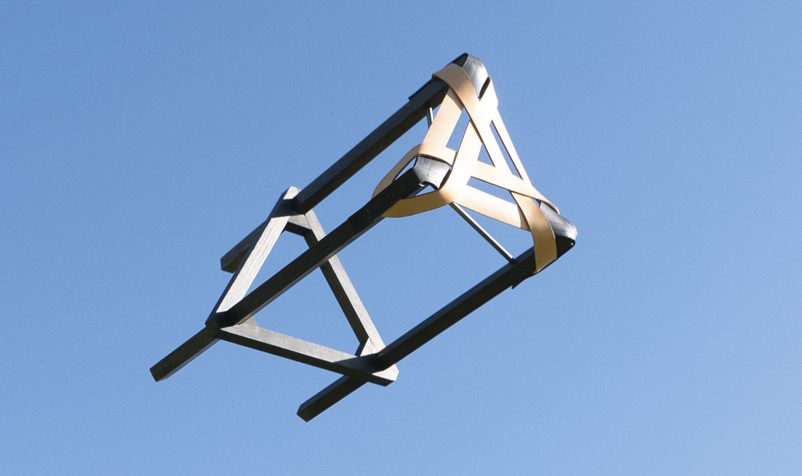 Saddle bar stool tossed in air with blue sky behind